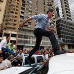 National Assembly President Juan Guaido, who declared himself interim president of Venezuela, leaps on to a vehicle to speak to supporters in Caracas, Venezuela. </br>(Eduardo Verdugo/AP/Shutterstock)